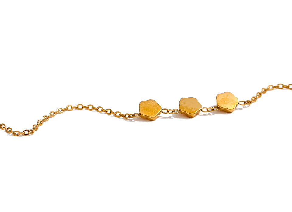 Guldhalsband i lågmäld men otrolig design av tre rosor i blänkande guld placerad på en vit bakgrund