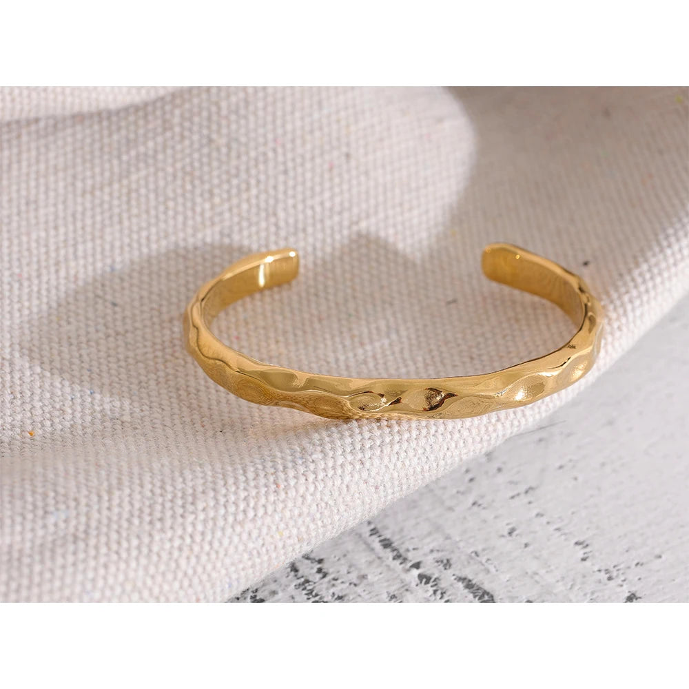 Enkelt och stilrent guld armband med öppning med en form av bucklor som design perfekt för vardag och fest| tillverkat för kvinnor.