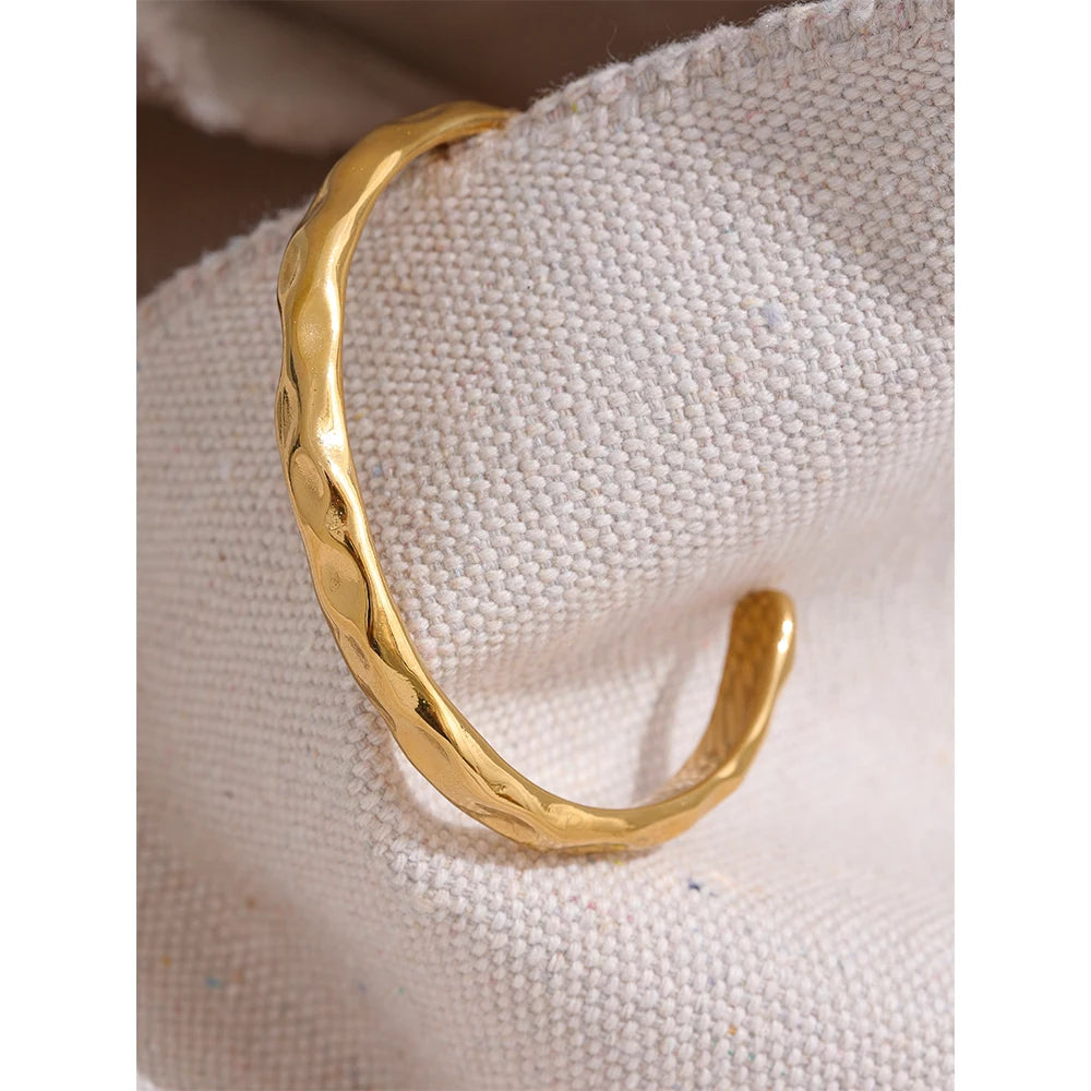 Enkelt och stilrent guld armband med öppning med en form av bucklor som design perfekt för vardag och fest| tillverkat för kvinnor.