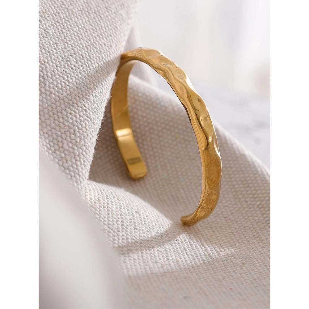 Enkelt och stilrent guld armband med öppning med en form av bucklor som design perfekt för vardag och fest| tillverkat för kvinnor.